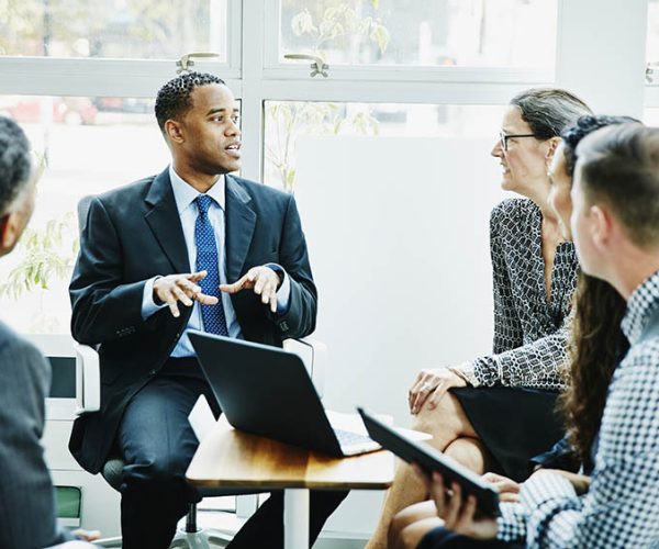 Businessman leading team meeting in office conference room